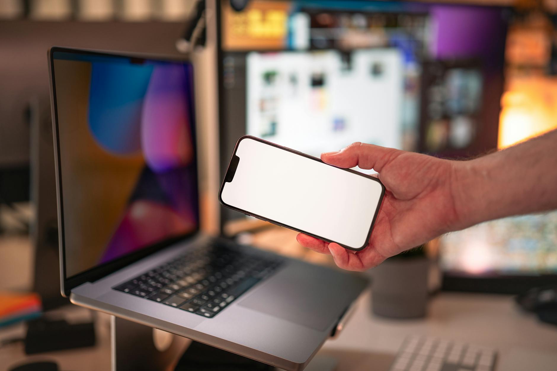 Smartphone blank screen mockup. Office interior. Laptop with external monitors equipment.
