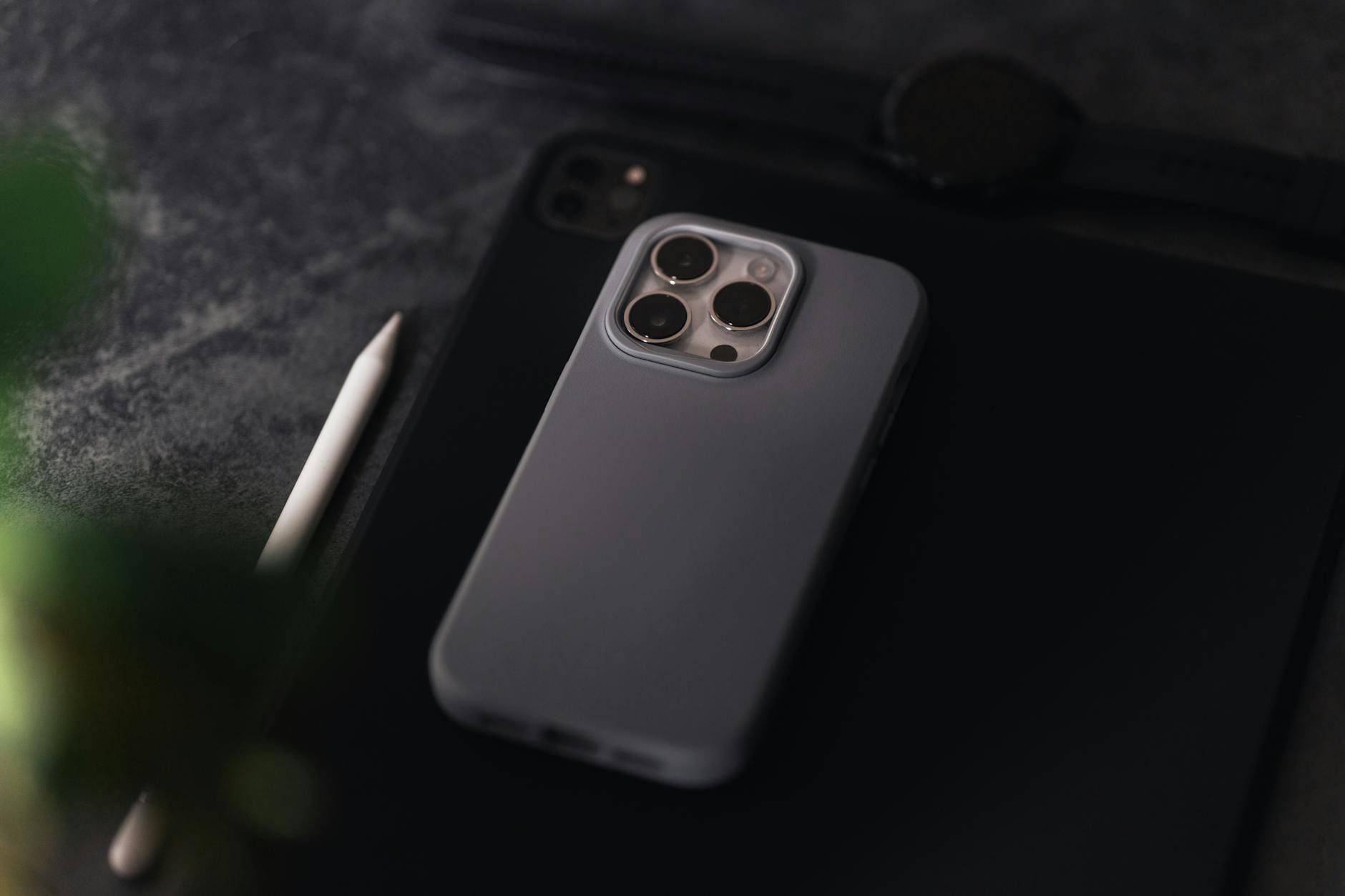 An iPhone and iPad Lying on a Gray Surface