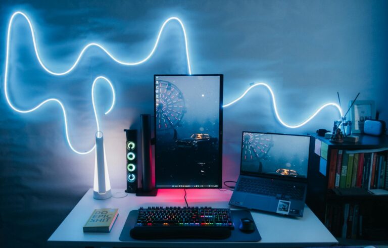 Modern Desk Setup with a Vertical Monitor, Laptop and a Neon Light on the Wall