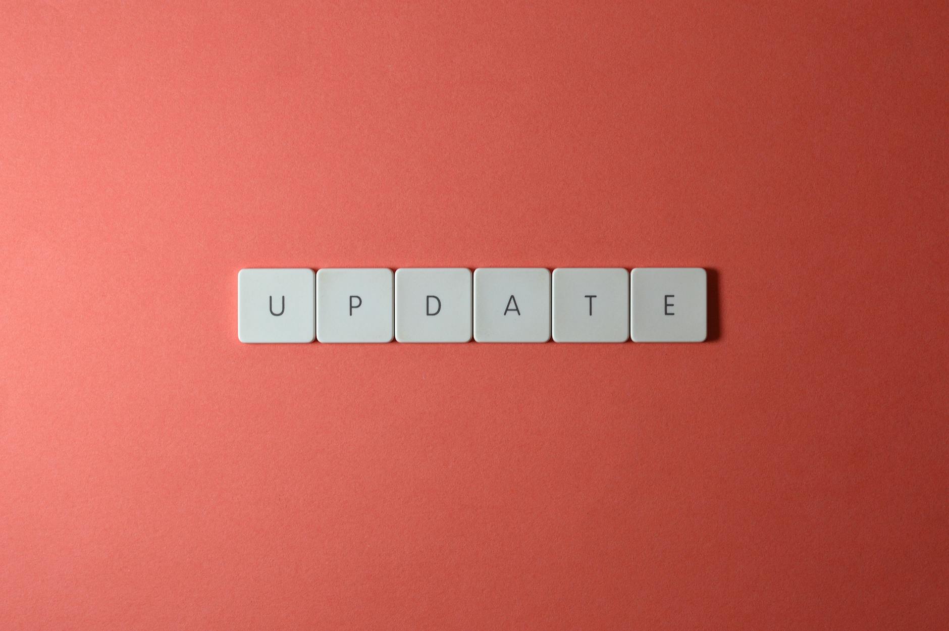 Keyboard keys arranged to spell 'update' on a vibrant red background, ideal for conveying tech concepts.